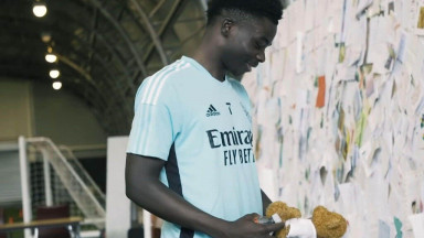 Saka smiles at a teddy bear as Arsenal fans showed their support with gifts and letters