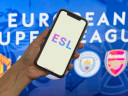 Person holding a phone in front of European Super League banner